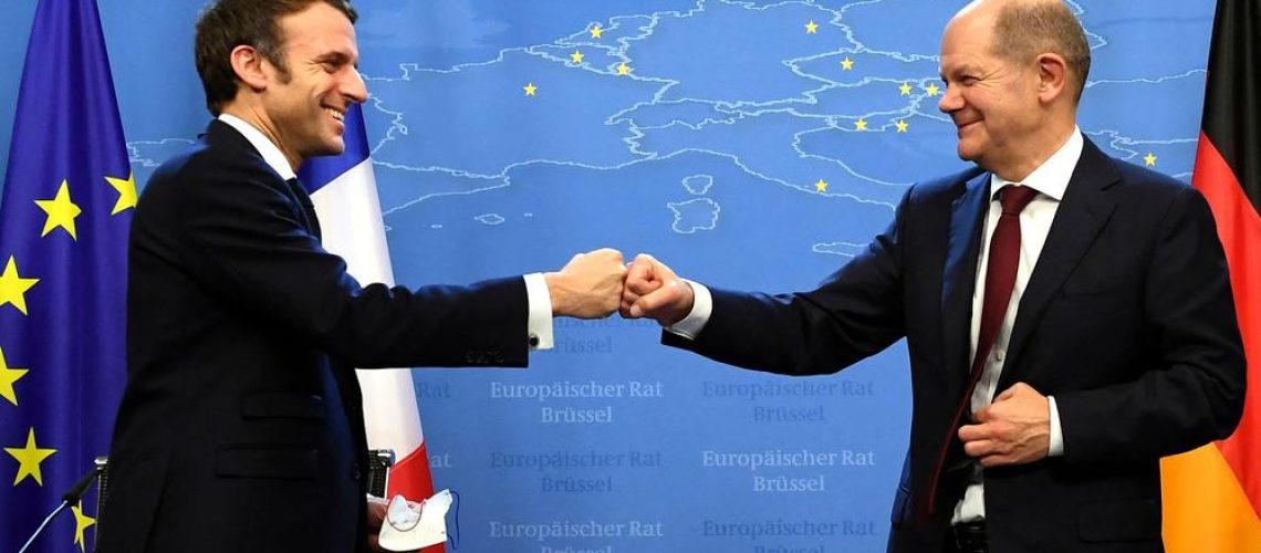 France's President Emmanuel Macron (L) and Germany's Chancellor Olaf Scholz bump fists after holding a joint press conference during an European Union (EU) summit at the European Council Building at the EU headquarters in Brussels on December 17, 2021. (Photo by JOHN THYS / POOL / AFP) BELGIUM-EU-POLITICS-SUMMIT